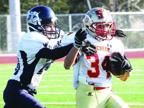 Sydenham's Brenden Monnier tries to get away from St. Mary's Crusaders' tackler Casey Abrams during Monday's EOSSAA junior football final at the Caraco Field. Michael Lea QMI Agency