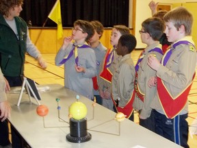 Pictured are Cubs looking at solar system models.