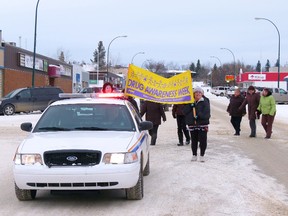 Kathryn Currie of Crossroads carries one side of the banner reading Drug Awareness Week, volunteer Cecilia Dutchak the other end, leading participants in the Addiction Free Walk of Hope down Main Street in Fairview on Nov. 14. (Chris Eakin/Fairview Post)