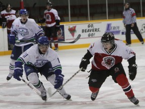 A Sudbury Nickel Baron and a Blind River Beaver race for the loose puck.