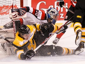 Ottawa 67’s goaltender Clint Windsor gets knocked down by the Kingston Frontenacs’ Henri Ikonen during Ontario Hockey League action at Scotiabank Place in Ottawa on Tuesday. (Errol McGihon/QMI Agency)