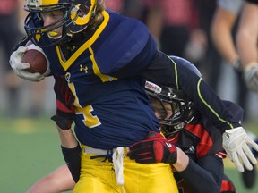 Matt Martin of the St. Joseph's Rams runs out of the grasp of Mitch Graves of the St. Thomas Aquinas Flames during their WOSSAA final game Tuesday Nov 20. 2012 at the Citywide Fields in London