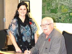 Mayor Bruce Marriott signs a proclamation marking the week of Nov. 18-24 as National Addictions Awareness Week, with Alberta Health Services employee Keily Stetson as a witness.