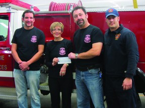 Daisy Dowhy of Central Plains Cancer Care accepts a cheque for $3,400 from Curtis Rance, Daren Van Den Bussche, and Jeff Tessier of the Portage Fire Department. The funds were raised from the Real Men Wear Pink t-shirt campaign held in October to support breast cancer awareness and research. (ROBIN DUDGEON/THE DAILY GRAPHIC/QMI AGENCY)