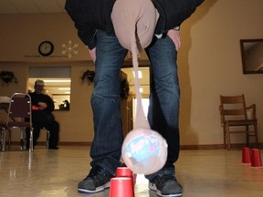 A racer uses his head to swing a ball in a pantyhose to knock down some plastic cups. This was one of the pit stops on the Melfort's Amazing Race.
