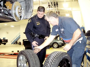 Chatham-Kent OPP Const. Aaron McPhail, left, and technician Doug Kane are shown at Victory Ford Lincoln on Thursday. VICKI GOUGH vicki.gough@sunmedia.ca