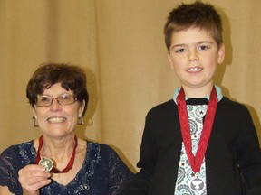 Mary Murdock, left, and Matteo Bissonnette were awarded YMCA Canada Peace Medallions by the Sudbury YMCA on Thursday. Bissonnette is holding up one of therecycled milk bag  products made by his great aunt. HAROLD CARMICHAEL/SUDBURY STAR/QMI AGENCY