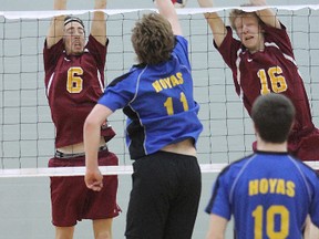 Regiopolis-Notre Dame’s Evan Stucke, left, and Eryk Freundorfer jump to block the spike by Huntsville’s Jason Connolly in the opening match Thursday morning of the Ontario high school boys AAA volleyball championship at Queen's University’s Athletic and Recreation Centre. (Michael Lea/The Whig-Standard)