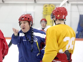 Martin Raymond, left, an assistant coach with the Tampa Bay Lightning, gives some instructions to Pat Pinder of the Royal Military College Paladins during a visit to their practice on Tuesday. (Ian MacAlpine/The Whig-Standard)
