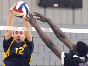 St. Michael Warriors' Brendon McLeod and Thornlea's Keishorn Jackson compete at the net during the Warriors' opening-match win at the OFSAA AA senior boys volleyball championship at Burnside Agriplex Thursday. SCOTT WISHART The Beacon Herald