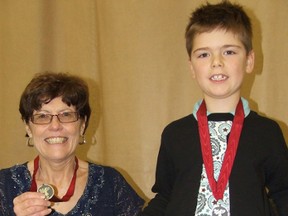 Mary Murdock. left, and Matteo Bissonnette were awarded YMCA Canada Peace Medallions by the Sudbury YMCA Thursday. Bissonnette is holding up one of the recycled milk bag products made by his great aunt.