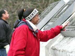 GARETT WILLIAMS/Daily Miner and News

Irene Taypaykejick runs a hand over a monument honouring more than 300 Grassy Narrows community member who attended residential schools at a dedication ceremony Thursday, Nov. 22, 2012.