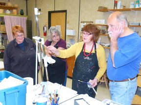 Bill Prince (far right) watches as instructor Patricia Peters shows him how he can improve on his painting during the Exploring Acrylics workshop at the Fairview Fine Arts Centre Nov. 17-18. Carol Dillon (far left) and Carolyn Adams watch to try and pick up a few pointers for their own paintings.
CHRIS EAKIN/FAIRVIEW POST/QMI AGENCY