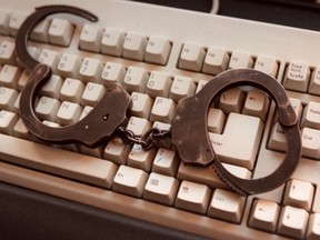 Handcuffs on a computer keyboard. (QMI Agency/SUZANNE BIRD)