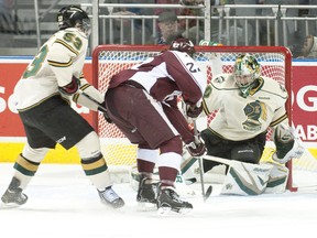 London goalie Kevin Bailie keeps his eye on the puck as Peterborough Petes forward Francis Menard moves in to take a shot while being trailed by Knights forward Bo Horvat during their OHL game at Budweiser Gardens on Friday night. (CRAIG GLOVER, The London Free Press)