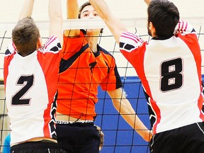 Two Ottawa Louis Riel Rebelles defenders try to block a Quinte Christian attacker during the OFSAA A boys volleyball final Saturday at QCHS. (Michael J. Brethour for The Intelligencer.)