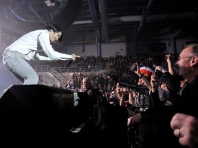 Journey lead singer Arnel Pineda connects with the crowd in the front row as he leads his band in a performance at a sold-out Canada Games Arena Saturday. The band headlined the show that included Night Ranger and Loverboy, which rocked the arena. (Adam Jackson/Daily Herald-Tribune)