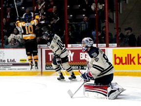 Windsor Spitfires goalie Jordan DeKort and defenceman Pat Sieloff share their disappointment as Kingston Frontenacs forward Billy Jenkins celebrates his second goal of the game during their Ontario Hockey League game yesterday in Windsor. The Frontenacs scored three goals in the second period en route to defeating the Spits 4-3. (JOEL BOYCE/QMI Agency)