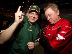 Edmonton Eskimos fan Rick Reschenthaler, left, (rooting for Toronto) poses with Calgary Stampeders fan Greg Alwast at Schanks on Sunday. (Codie McLachlan/Edmonton Sun)