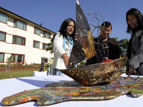 In this photograph taken on November 19, 2012 visitors look at art made from trash collected on Mount Everest, in Kathmandu.  A group of artists is staging an exhibition of sculpture made from tonnes of trash collected on Mount Everest, highlighting the toll that decades of mountaineering have taken on the world's highest peak. AFP PHOTO/Prakash MATHEMA
