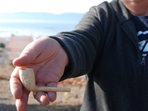 Paula Matheson (inset) displays a pipe, manufactured in Montreal in the 1800s, she found on the waterfront near her Plummer Additional home.