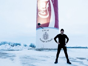 Mark McIntyre stands near the World's Largest Coke Can during a stop in Portage la Prairie last Friday.  The Ontario man is hitchhiking from Vancouver to Truro in 21 days to raise awareness on cancers below the waist for the Canadian Cancer Society.  (Submitted photo)