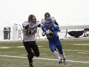 Ardrossan Bisons running back Jimmie Airey couldn’t always escape the clutches of the large-looking Drumheller defence, as the Herd lost to the Titans in the Tier IV final for the season year in a row. Photo by Shane Jones/Sherwood Park News/QMI Agency