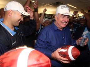 Argos GM Jim Barker (right) holds a game ball after it was awarded to him by head coach Scott Milanovich after the Argos win the 100th Grey Cup at the Rogers Centre in Toronto Nov. 25, 2012. (CRAIG ROBERTSON/Toronto Sun)