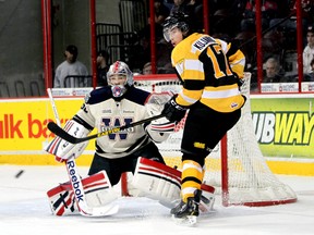 Kingston Frontenacs forward Ryan Kujawinski watches a shot directed at Windsor Spitfires goalie Jordan DeKort at the WFCU Centre in Windsor on Sunday afternoon. The Frontenacs scored three goals in the second period, beating the Spitfires 4-3 in Ontario Hockey League action. (Joel Boyce/QMI Agency)