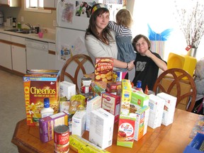 Camera shy Kirvayah Miner, 4, with mom Amanda and brother Kaein with the birthday gifts of food she received instead of presents for donation to the Miracle Marathon broadcast live by CJRL 89.5 the Lake at the Super 8 Minis Hall, Friday and Saturday.
REG CLAYTON/Daily Miner and News