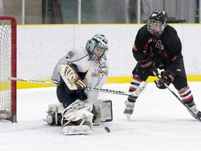 Golden Arrow Bantam AAA Storm goalie Tyson Walker sticks out the pad to make a save on Cole Johnson. The Grande Prairie Storm hosted the Lloydminster Heat in Alberta Major Bantam Hockey League play at Dave Barr Arena in Grande Prairie, Saturday. (Terry Farrell/Daily Herald-Tribune)