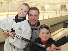 Jim Hulton inside Centre 70 with his sons Jimmy, left, and Lucas and a hockey stick autographed by Sidney Crosby. In October, Hulton, a former junior head coach and NHL assistant coach, co-ordinated on-ice drills at a couple of conditioning camps for locked-out NHL players, including Pittsburgh Penguins star Crosby. (Michael Lea/The Whig-Standard)