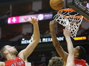 Raptors' Jonas Valanciunas goes for a rebound against Rockets centre Omer Asik during Tuesday's game in Houston. (REUTERS)
