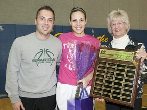 Mother Teresa Spartans basketball player Rebecca Harmsworth is joined by her coach, Jami Pizzari, left, as she is presented with the Fran Wigston Award by Fran Wigston-Eberhard during halftime at the TVRA all-star game at Strathroy District Collegiate Institute in Strathroy on Tuesday. The award is given to the outstanding graduating player as voted by coaches and members of the media. (CRAIG GLOVER, The London Free Press)