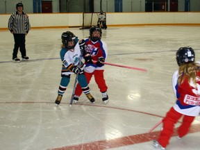 Viktoria Mlynarski, left, of Paris' Team Wight U10 ringette squad checks a Hamilton player at Inch Park Arena in Hamilton on Saturday, Nov. 24, 2012. SUBMITTED PHOTO