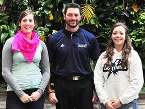 CArly Marchment, left, and Jackie Rochefort, right, pose with Nipissing Lady Lakers hockey coach Darren Turcotte