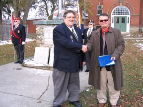 The war memorial plaques that were once part of the stone cairn in front of Beachville Public School have been passed from the Thames Valley District School Board to the Beachville Legion branch. About 30 people were at a short ceremony Wednesday, Nov. 28 where trustee Bill McKinnon, right, and branch president Ray Thornton signed the deed of gift from the school board.