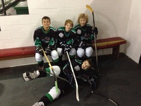 SUBMITTED PHOTO. From left to right are Taite Jessen, Josh Conley and Cam Little with Pass resident Spencer Dorge below. The three boys traveled from Pincher Creek this season to play Pee Wee hockey, as Pincher Creek did not have enough players to ice a team.