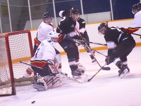 KEVIN RUSHWORTH PHOTO. The puck flies away after a battle at the Fort Macleod net