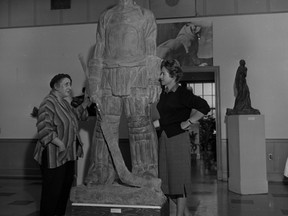 Toronto artist Frances Loring, left, and curator Paddy O?Brien flank Loring?s seven-foot-nine plaster model for a planned bronze sculpture Goal Keeper at the old London art gallery on Queens Ave. The Loring work was so big it had to be lifted in through a second-storey window for the November, 1962 exhibition. (Free Press file photo)