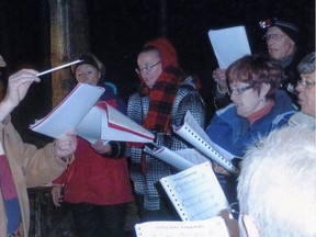 Jerome Collins, left, directs the Holy Angels' Choir at the Christmas Spirit Walk at Springwater Conservation Area. The annual evening is Dec. 1.