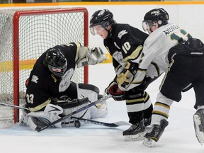 Trenton Golden Hawks' Andrew Winsor makes a save on Cobourg Cougars' Colbie Andrews as teammate Erlich Doerksen boxes Andrews out during the Hawks' 6-2 win Friday at the Community Gardens.