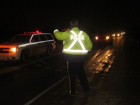 Constable Kuffner gets ready to pull a line of traffic aside at a check stop located on Highway 627 and Windermere Rd. This was one of several check stops that will be set up during the holidays.
