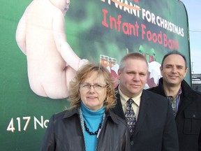 Helen Nicholas, Infant Food Bank interim director, left, Pastor Jack Flietstra, past chairman of the IFB, centre, and Dave Petryna, of Petryna Advertising, which helped create and is promoting this year's All I Need for Christmas Campaign, stand in front of one of six campaign  billboards that will be set across the city starting Saturday. HAROLD CARMICHAEL/SUDBURY STAR/QMI AGENCY