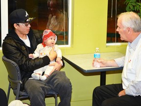 Four-month-old Avery Bull seems as interested as his father Jesse is in the talk by NorQuest College community relations manager Phil Chatters during the NorQuest College's Wetaskiwin campus' open house held Nov. 21, 2012. The Hobbema father is a student at NorQuest college where he's taking academic upgrading with plans on enrolling in the social worker program next September.