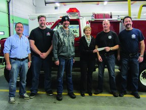 Daisy Dowhy of Central Plains Cancer Care accepts a cheque for $2,930 from the Portage Fire Department from its Movember campaign, Friday. Pictured are L-R George Kerr, Ryan Draycott, Curtis Rance, Todd McKinnon, and Daren Van Den Bussche. (ROBIN DUDGEON/THE DAILY GRAPHIC/QMI AGENCY)