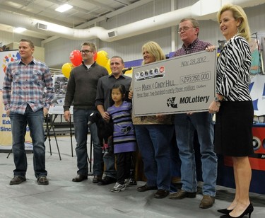 The Hill family holds an oversized check presented by Missouri Lottery director May Scheve (R) during a news conference at the North Platte High School in Dearborn, Missouri, November 30, 2012. The Hill family bought one of the two winning tickets for a record $588-million Powerball lottery from the Trex Mart truck stop in Dearborn, Missouri. (L-R) Sons Jason, Cody, Jarod, adopted daughter Jaiden, and Cindy and Mark Hill.  REUTERS/Dave Kaup