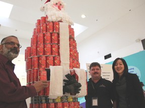 CANstruction chair Joe Lobo, left, with Myles Vanni, executive director of the Inn of the Good Shepherd, and Adrienne Lee, marketing manager of Lambton Mall, show off a larger than life Santa Claus Friday. Organizers are hoping to collect 40,000 lbs. of pound from the second annual building contest. (BARBARA SIMPSON, The Observer)