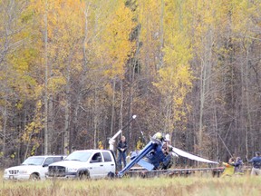 Transportation Safety Board of Canada investigators load the wreckage of a helicopter onto a flatbed truck on Oct. 6, 2011, a day after the helicopter crashed in a farmer's field killing the pilot.