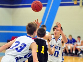 Liam Andrews, right, of the TH&VS Blues, accepts a pass as his teammate Tyson Malo and Sheldon Flanningan, of the TDSS Saints, look on during the first half of a junior game at the 38th annual Gold Cup Classic Basketball Tournament on Friday.